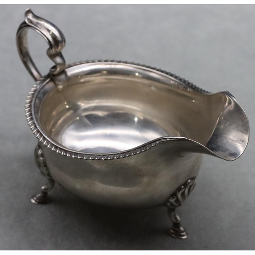 381 - A Birmingham silver sauce boat with gadroon rim, scroll handle on splayed hoof feet, maker Walker & ... 