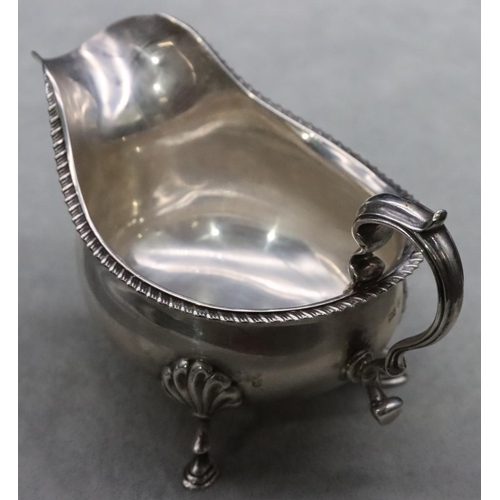 381 - A Birmingham silver sauce boat with gadroon rim, scroll handle on splayed hoof feet, maker Walker & ... 