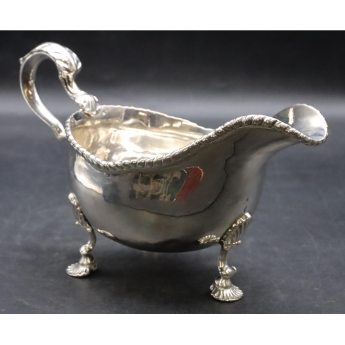 387 - An 18th Century George III silver sauce boat with gadroon rim, scroll handle on shell shaped feet, L... 