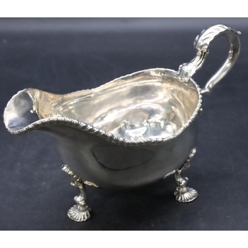 387 - An 18th Century George III silver sauce boat with gadroon rim, scroll handle on shell shaped feet, L... 