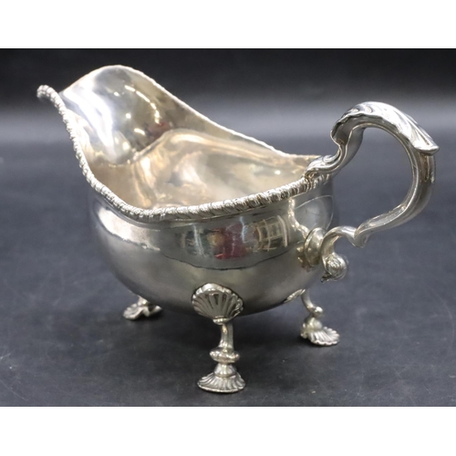 387 - An 18th Century George III silver sauce boat with gadroon rim, scroll handle on shell shaped feet, L... 