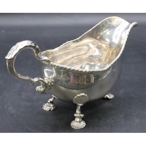 387 - An 18th Century George III silver sauce boat with gadroon rim, scroll handle on shell shaped feet, L... 