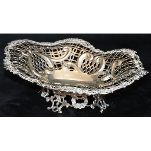 388 - A Victorian silver oval basket with scallop shape and pierced floral, leaf and scroll rim, splayed b... 