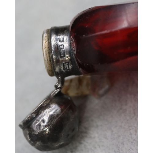 392 - A ruby glass scent bottle with Birmingham silver neck and hinged lid (lid dented) enclosing inner st... 