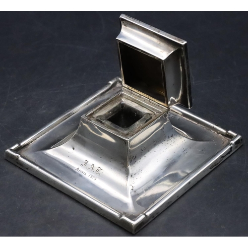 414 - A Birmingham silver square inkwell with hinged lid enclosing glass inkwell, on weighted splayed base... 