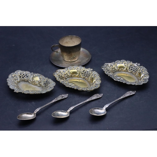 432 - A Continental silver coloured metal cup and saucer with chased floral and leaf decoration, 3 x 830 s... 