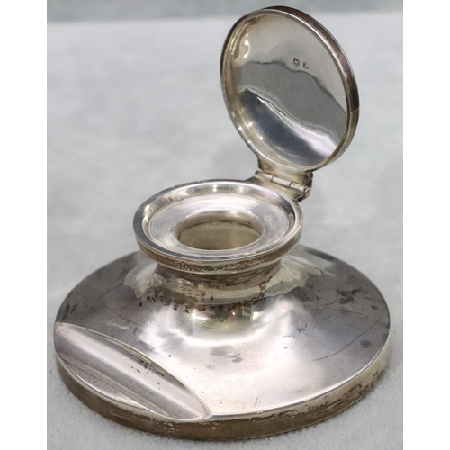 444 - A Birmingham silver round inkwell with hinged lid enclosing liner on sweeping base, 8.5cm diameter