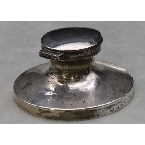 444 - A Birmingham silver round inkwell with hinged lid enclosing liner on sweeping base, 8.5cm diameter