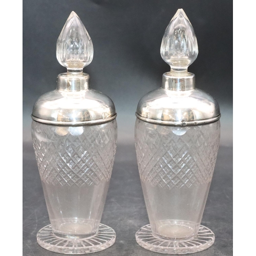 461 - A pair of cut glass round bulbous shaped scent bottles with stoppers and silver shoulders and necks ... 