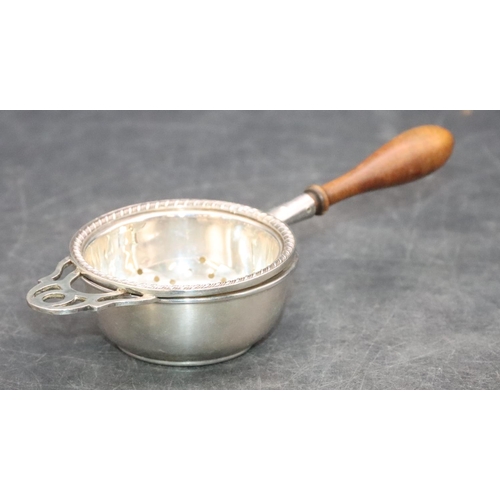 466 - A modern London silver tea strainer with turned wooden handle and similar stand, overall weight 1.7o... 