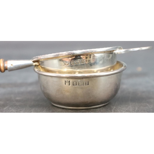 466 - A modern London silver tea strainer with turned wooden handle and similar stand, overall weight 1.7o... 