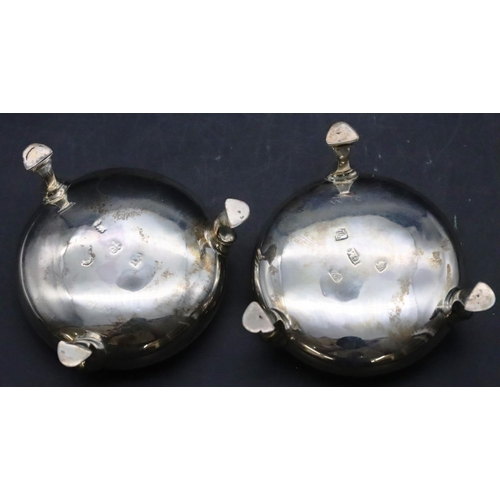 474 - A pair of George III silver round bulbous shaped salts with blue glass liners on splayed hoof feet, ... 