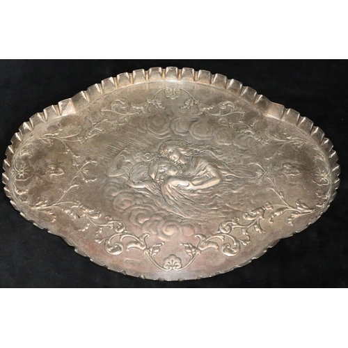 486 - An Edward VII silver scallop shaped dressing table tray with embossed figure, floral and scroll deco... 