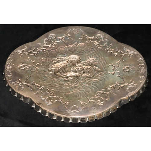 486 - An Edward VII silver scallop shaped dressing table tray with embossed figure, floral and scroll deco... 