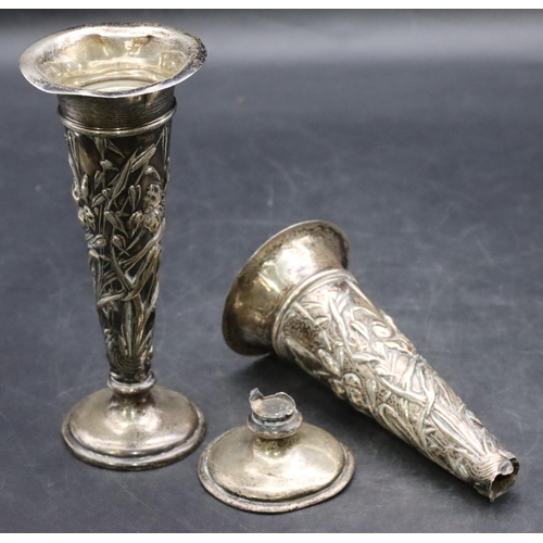 493 - A pair of London silver round trumpet shaped spill vases with embossed floral and leaf decoration on... 