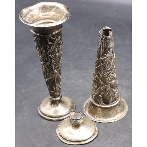 493 - A pair of London silver round trumpet shaped spill vases with embossed floral and leaf decoration on... 