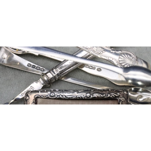 494 - A pair of Georgian plain silver sugar tongs, another pair of Sheffield silver sugar tongs, 2.2oz, a ... 