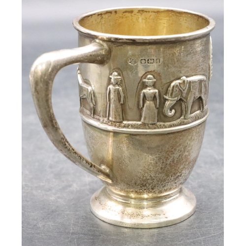 499 - A George VI silver child's christening mug with raised procession of 2 figures, elephant, giraffe, l... 