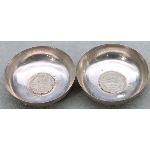 504 - A pair of Continental silver coloured metal small round dishes inset with Arabic coins with allover ... 