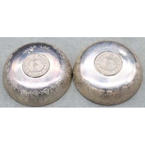 504 - A pair of Continental silver coloured metal small round dishes inset with Arabic coins with allover ... 