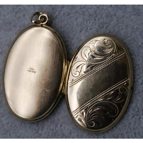 729 - A 9ct gold oval locket with chased scroll hinged front, 5.3 grams gross