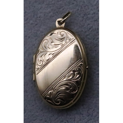 729 - A 9ct gold oval locket with chased scroll hinged front, 5.3 grams gross