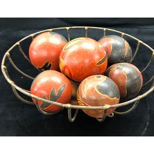 9004 - 7 hand painted aboriginal seed balls, largest 9cm diameter and a metal fruit basket.