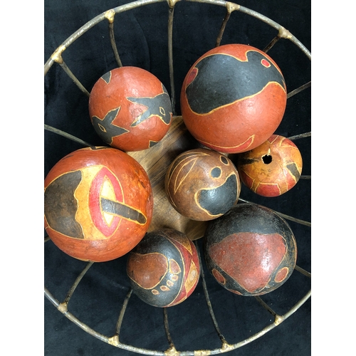 9004 - 7 hand painted aboriginal seed balls, largest 9cm diameter and a metal fruit basket.