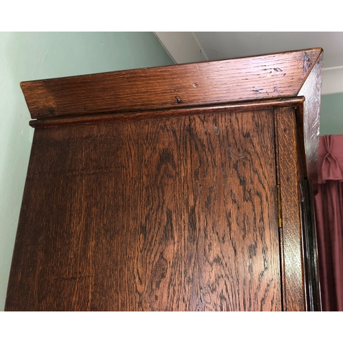 9009 - An oak double cupboard with 2 panel doors, brass lock and key (later sides), enclosing interior uppe... 