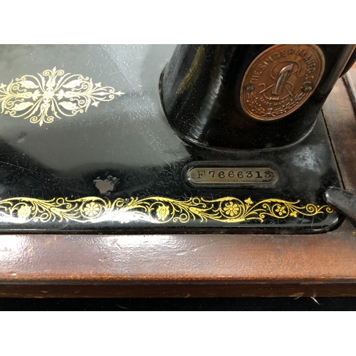 9024 - A vintage Singer sewing machine with original wood carrying case, model number F7666313, with lock a... 