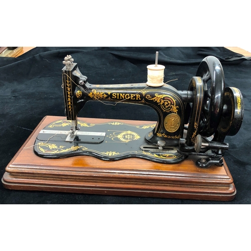 9049 - A vintage manual Singer sewing machine in original wood case. with additional spools for shuttle.