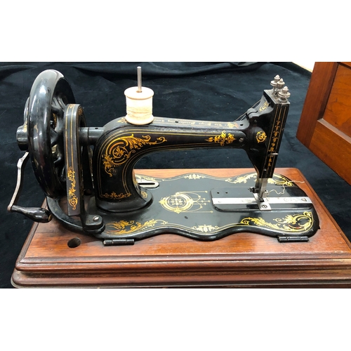 9049 - A vintage manual Singer sewing machine in original wood case. with additional spools for shuttle.