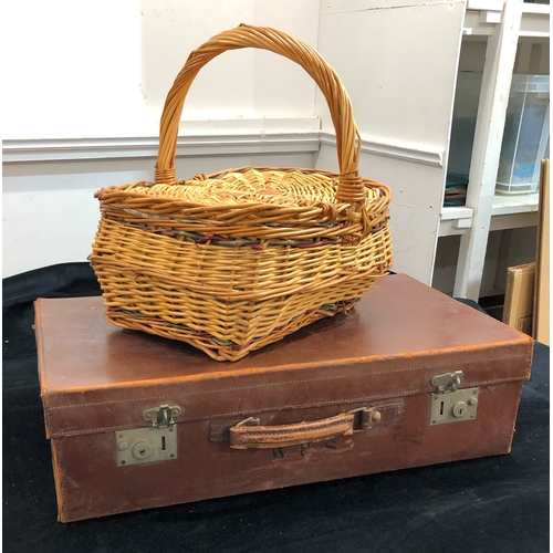 9076 - A Brown leather suitcase, 66cm wide, 38cm deep, 18 cm high and a wicker picnic basket. (2)