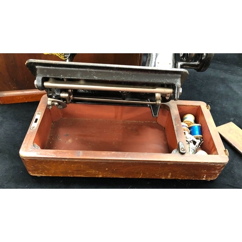 9024 - A vintage Singer sewing machine with original wood carrying case, model number F7666313, with lock a... 