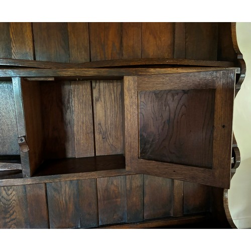 9223 - An oak dresser (in 2 pieces), 2 shelves above the main dresser with 4 peg hooks to sides, plate hold... 