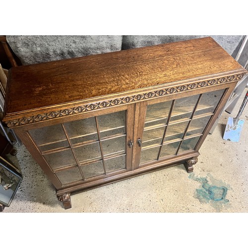 9194 - A Waring & Gillows 1930's oak low bookcase with 2 glass panelled doors on bulbous front supports wit... 