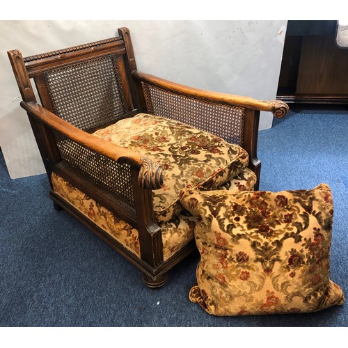 9234 - A 1920's oak Bergere armchair with scroll arms and Bergere sides and back, on bun feet with feather ... 