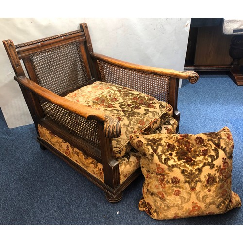 9234 - A 1920's oak Bergere armchair with scroll arms and Bergere sides and back, on bun feet with feather ... 