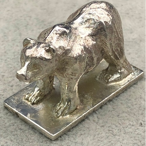 9257 - A small silver coloured metal model of a standing bear (marks rubbed), 4cm long, 57 grams