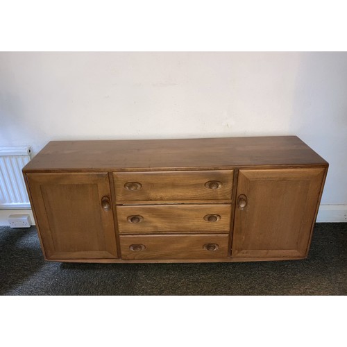 9129 - An Ercol elm Windsor sideboard with 3 central drawers and interior cutlery tray, 2 doors, on castors... 