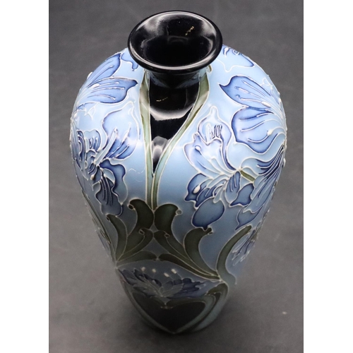 11 - A modern Moorcroft small round bulbous thin necked vase on pale blue ground with allover floral and ... 