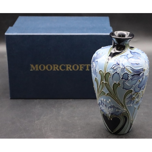 11 - A modern Moorcroft small round bulbous thin necked vase on pale blue ground with allover floral and ... 