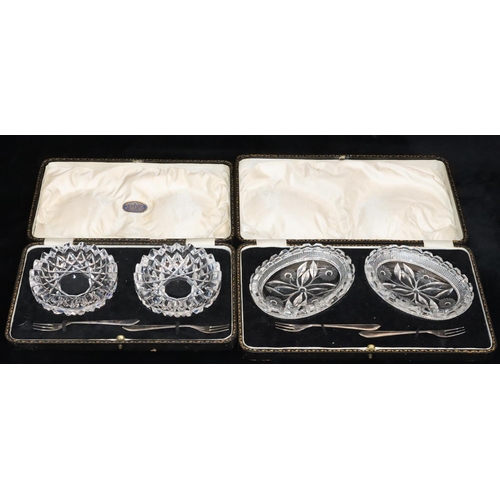 13 - A pair of oval cut glass butter dishes with floral motifs and a pair of silver plated forks in fitte... 