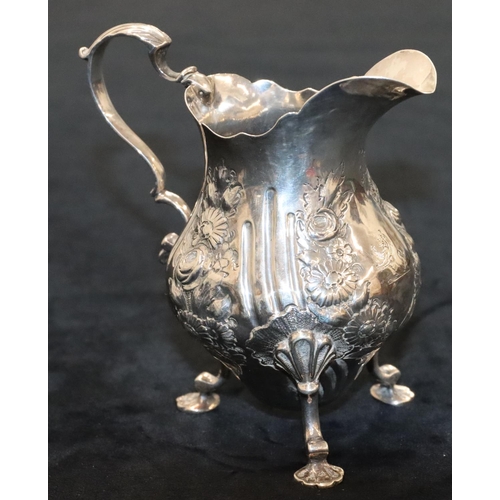 144 - A Victorian silver round bulbous shaped milk jug with crinkled rim, scroll handle with allover embos... 