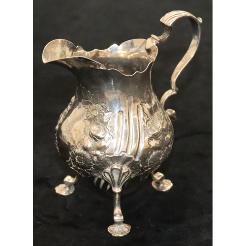 144 - A Victorian silver round bulbous shaped milk jug with crinkled rim, scroll handle with allover embos... 