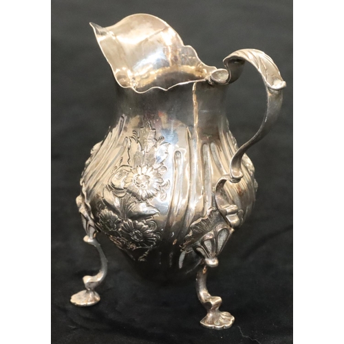 144 - A Victorian silver round bulbous shaped milk jug with crinkled rim, scroll handle with allover embos... 