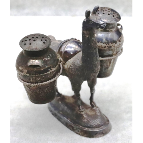 181 - A Continental silver coloured metal figure of an alpaca carrying 2 bulbous 2-handled pepper pots on ... 