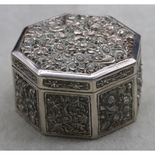 237 - An Oriental silver coloured metal octagonal shaped pierced box with embossed floral and leaf decorat... 