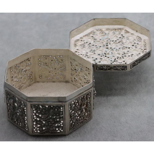 237 - An Oriental silver coloured metal octagonal shaped pierced box with embossed floral and leaf decorat... 