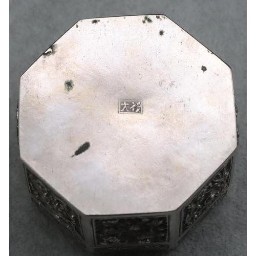 237 - An Oriental silver coloured metal octagonal shaped pierced box with embossed floral and leaf decorat... 